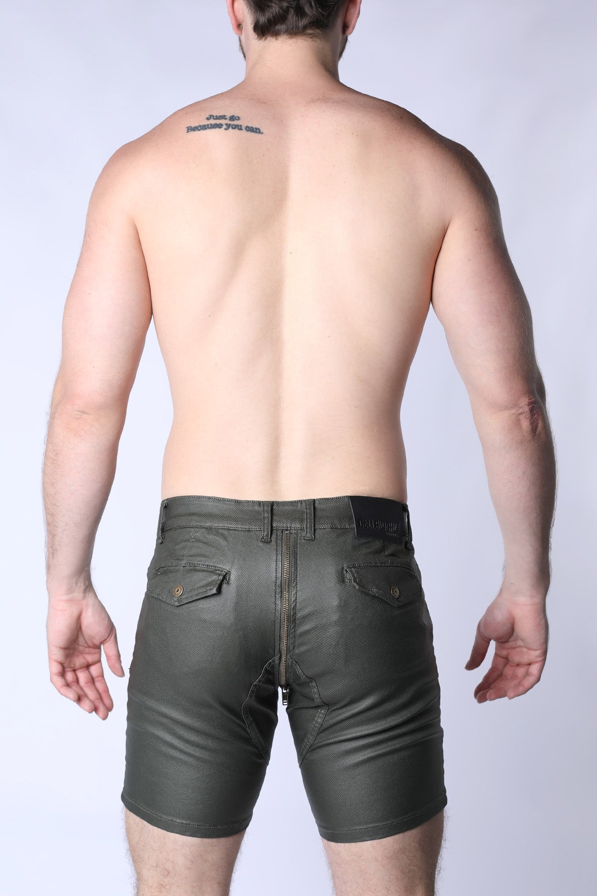 Man wearing dark green leather shorts on a white background