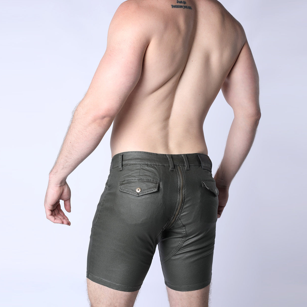 Person wearing dark green shorts on a plain background