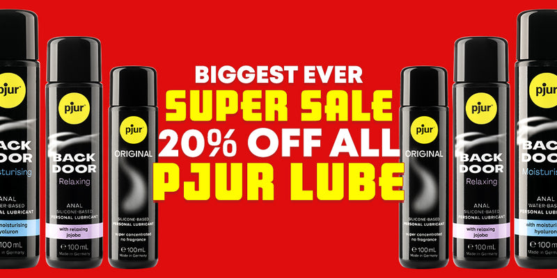 A promotional banner for Pjur Lube featuring multiple aerosol cans of anal and sexual lubricants on both sides of large yellow and white text that reads 'BIGGEST EVER SUPER SALE 20% OFF ALL PJUR LUBE' on a solid red background.